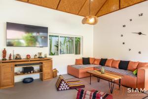 a living room with a couch and a tv at Villa Sumalee 3Br Private Pool in Koh Samui 