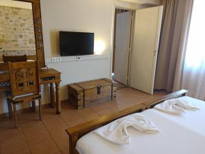 a hotel room with two beds and a television at Simosmare Resort in Elafonisos