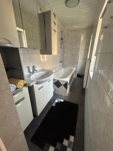 a bathroom with a sink and a bath tub at Große Ferienwohnung in Klagenfurt