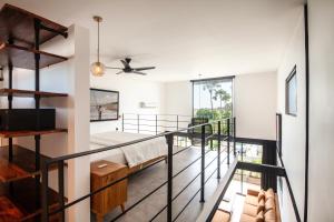 a room with a balcony with a bed and a ceiling fan at Lofty Nyc Vibes 200m To Canggu Beach in Canggu