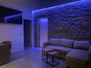 a living room with a couch and a stone wall at Sandra's House in Izola