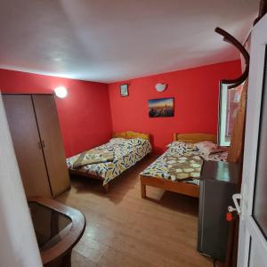 two beds in a room with red walls at Casa Mititelu in Costinesti