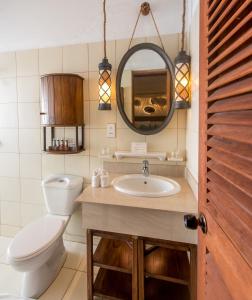 a bathroom with a toilet and a sink and a mirror at Makunudu Island in Makunudhoo