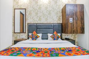 a bedroom with a large bed with a colorful blanket at FabHotel Prime Taj Castle in Amritsar