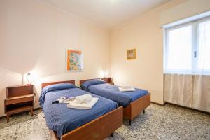 Un dormitorio con dos camas y un televisor y una ventana. en Tre Balconi Sul Mare Beach - Happy Rentals, en Borghetto Santo Spirito