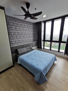 a bedroom with a blue bed and a ceiling fan at H20 Residence Ara Damansara Petaling Jaya in Petaling Jaya