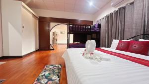 a bedroom with two beds with red and white pillows at The Sun House in Hua Hin