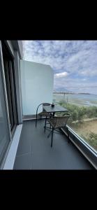 een balkon met een tafel en uitzicht op de oceaan bij Apartment sea view chalkida in Chalkida