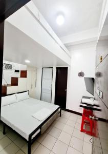 a bedroom with a bed and a desk in it at Dasma Lofts Hotel near Dela Salle Dasma in Dasmariñas