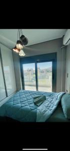 een slaapkamer met een groot bed en een groot raam bij Apartment sea view chalkida in Chalkida