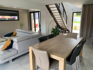 a living room with a wooden table and a couch at Superbe villa avec piscine proche de belfort in Meroux