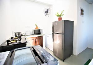 a kitchen with a stainless steel refrigerator and a stove at Sea Shell Villa Hikkaduwa 2 Separate Cabanas Ocean Front Villa in Hikkaduwa