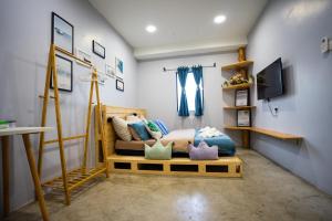 um quarto com uma cama com almofadas em Buddy Station em Semporna