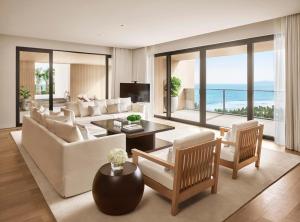a living room with white furniture and a view of the ocean at The Sanya EDITION in Sanya