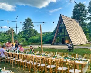 a long table with chairs and people sitting at it at Cabana A Vaideeni in Vaideeni