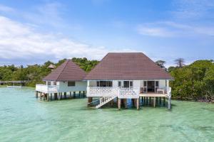 two houses on stilts in the water at Chale Island Resort in Chale Island