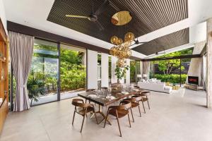 a dining room with a long table and chairs at Villa Raku in Koh Samui