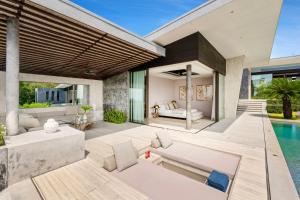 an outdoor living room with a pool and a villa at Villa Raku in Koh Samui