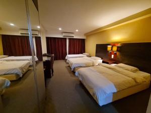 a hotel room with three beds in a room at SUN GARDEN Studio and Residences at South China Sea Place Suites in Kota Kinabalu
