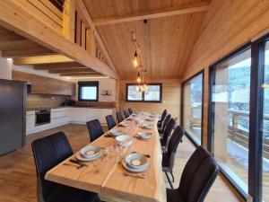 ein großes Esszimmer mit einem langen Tisch und Stühlen in der Unterkunft Chalet Victorine, vue imprenable avec spa in Gérardmer
