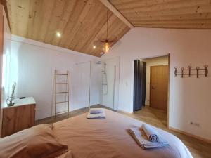 a bedroom with a large bed with towels on it at Chalet Victorine, vue imprenable avec spa in Gérardmer