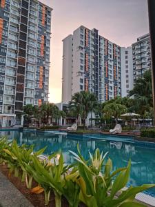 uma piscina em frente a alguns edifícios de apartamentos em Timurbay Seafront Residence Mawar Inap Homestay em Kuantan