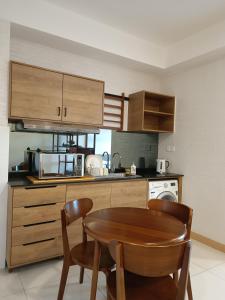 a small kitchen with a wooden table and chairs at Timurbay Seafront Residence Mawar Inap Homestay in Kuantan