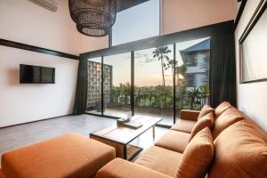a living room with a couch and a large window at Lofty Nyc Vibes 200m To Canggu Beach in Canggu
