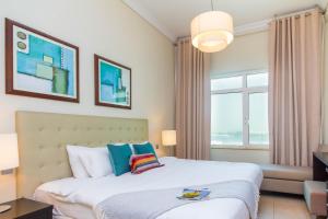 a bedroom with a bed and a large window at Bespoke Holiday Homes - Palm Jumeirah- 1 Bedroom Sea View with Pool & Beach Access, Al Haseer in Dubai