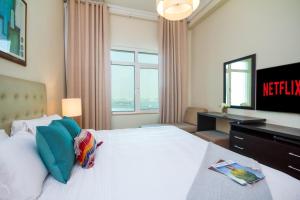 a hotel room with a bed and a television at Bespoke Holiday Homes - Palm Jumeirah- 1 Bedroom Sea View with Pool & Beach Access, Al Haseer in Dubai