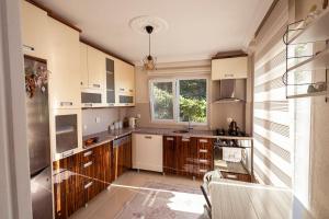 a large kitchen with wooden cabinets and a window at Doğanın İçindeki Yeriniz in Rize