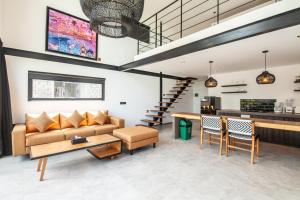 a living room with a couch and a table at Lofty Nyc Vibes 200m To Canggu Beach in Canggu