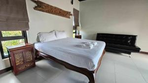 a bedroom with a bed and a table and a window at Blu Village Pool Villa in Bang Tao Beach