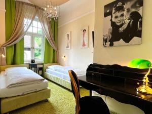 a bedroom with a piano and a bed and a desk at PARK VILLA zentral am Mittelrhein in Boppard
