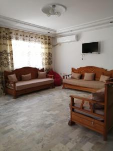 sala de estar con 2 sofás y TV en JasminVilla, en Sousse