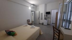 Zimmer mit einem Tisch und 2 Stühlen sowie einem Zimmer mit einem TV in der Unterkunft Galleria 38 in Soverato Marina
