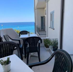 un patio con tavoli, sedie e vista sull'oceano di Galleria 38 a Soverato Marina