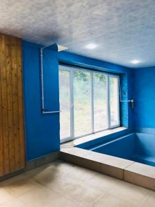 a blue room with a large window and a bath tub at Gorge of Tatev in Tatʼev