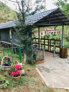 a pavilion with baskets of flowers in a garden at Gorge of Tatev in Tatʼev