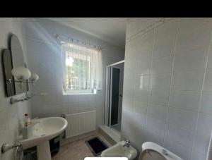 a white bathroom with a sink and a toilet at Willa Aqua, Parkplatz inklusive in Świnoujście