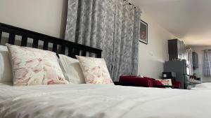 sypialnia z łóżkiem z białą pościelą i poduszkami w obiekcie Amazing Studio near CBD w mieście Mombasa