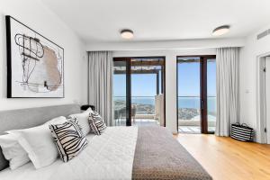 Un dormitorio blanco con una cama grande con almohadas. en Stunning Villa UV09 Oniro with Sea Views, Aphrodite Hills, en Kouklia 50 fotos más