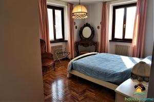 een slaapkamer met een bed, een spiegel en ramen bij Lake Garda Home in Riva del Garda