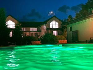 una piscina frente a una casa por la noche en Oasis family apartments en Sanzhiyka