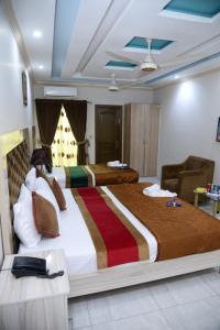 拉合爾的住宿－Hotel Deluxe Johar Town Lahore，酒店客房,设有两张床和一张沙发