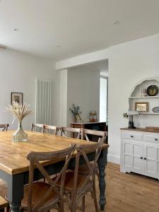 a kitchen and dining room with a wooden table at The Old Tearoom At Ty Llywelyn By Birch Stays in Conwy