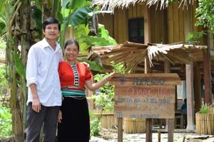 un homme et une femme debout devant un panneau dans l'établissement Homestay in Da Bia - Community Based Tourism, à Hòa Bình