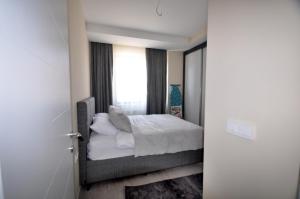 a bedroom with a bed with white sheets and a window at Arpaçay Apart Otel in Kars