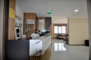 a man sitting at a counter in a lobby at Arpaçay Apart Otel in Kars