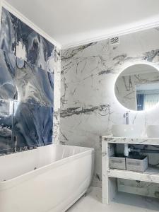 a white bathroom with a tub and a sink at Paris Dream Villa in Villejuif